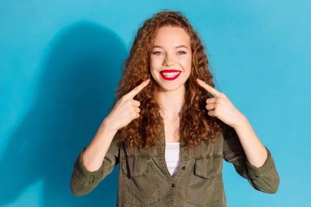 a woman pointing to her perfect teeth