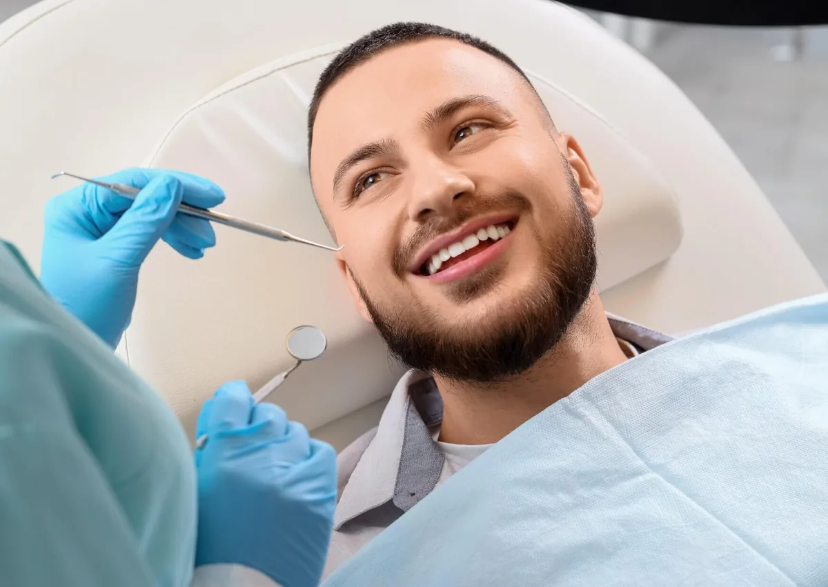 Patient smiling during a dental consultation for veneers to improve the appearance of his teeth.